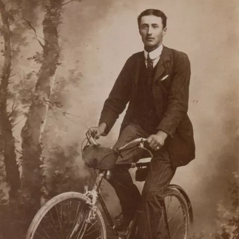 Photographie en noir et blanc d'un homme sur un vélo