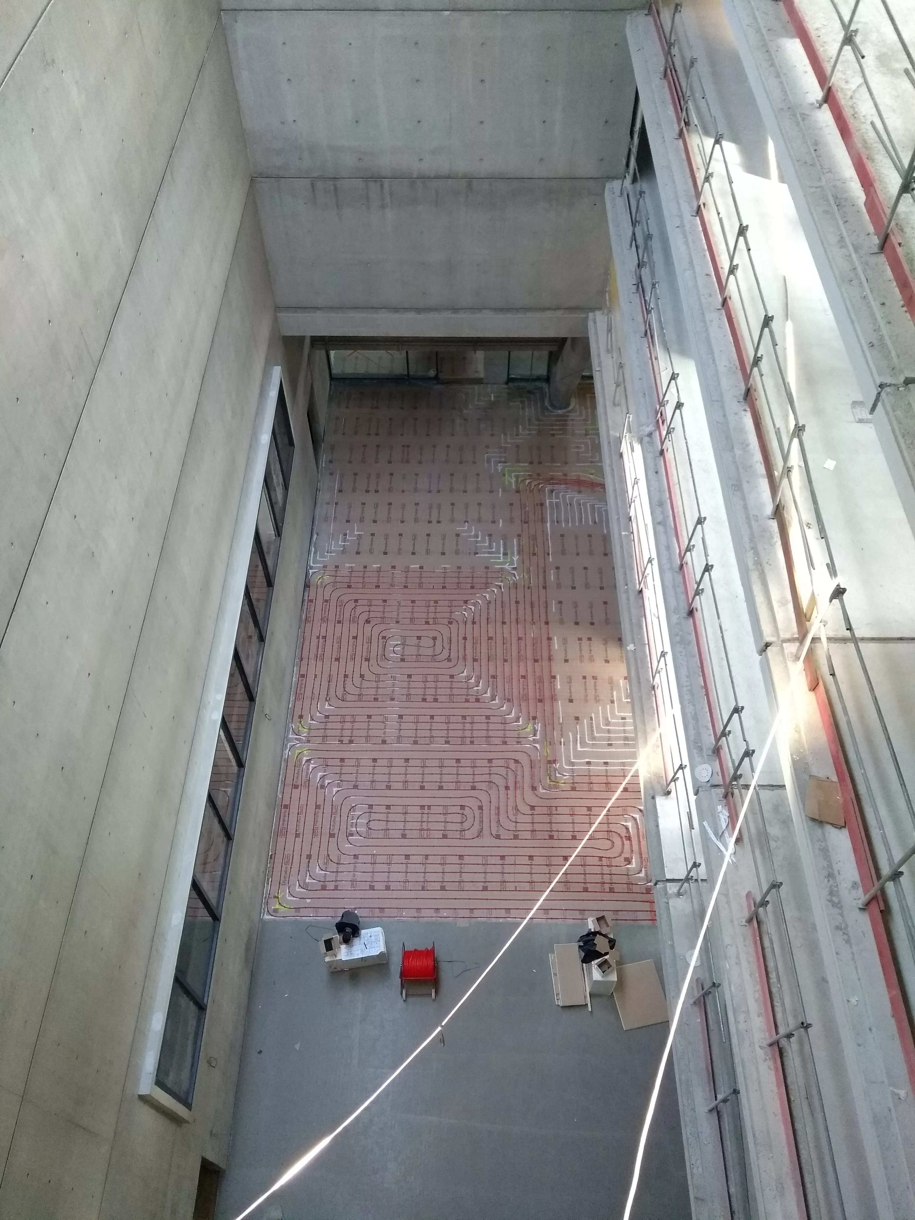 Pose du chauffage au sol dans la rue intérieure du bâtiment des Archives départementales de l'Isère à Saint-Martin-d'Hères
