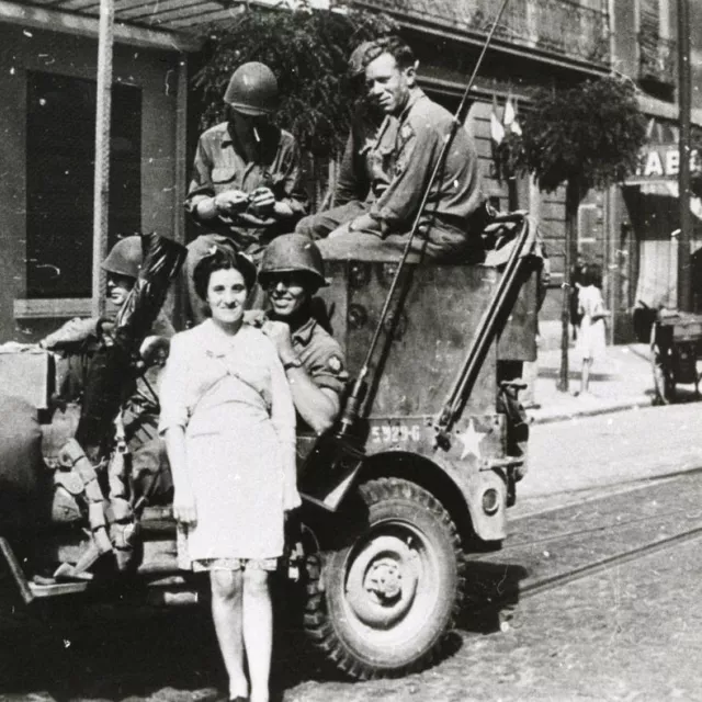 Photo de soldats posant avec une civile à la Libération (26FI27)